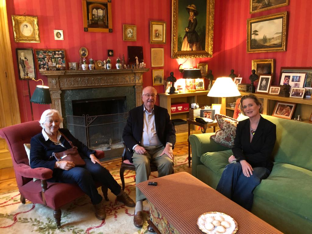 King Albert sitting in a chair beside Queen Paola and his love child Delphine Boel, now Princess Delphine of the Belgians.