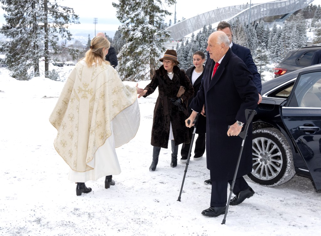 King Harald on crutches in the snow and Queen Sonja shaking a clergywoman's hand